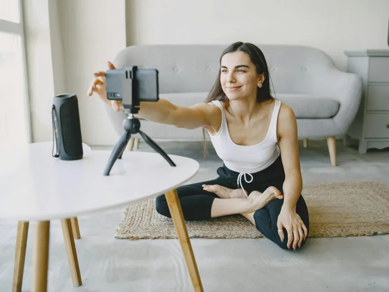 Woman recording a yoga video for her online audience.